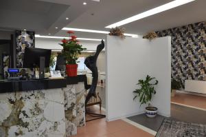 an office with a desk with a black sculpture on the wall at Green Hotel in Vergiate