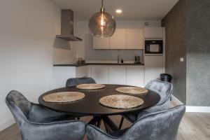 a dining room table with chairs and a kitchen at Luxe 3-kamer Penthouse met dakterras in het centrum van Hoorn in Hoorn