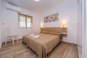 a bedroom with a bed and a chair and a window at San Jaime View - stunning sea views close to resort in Son Bou +19 photos