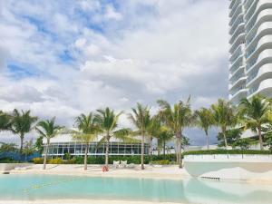 a view of a resort with palm trees and a building at Freila's Azure North in San Fernando