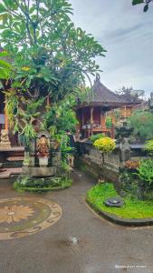 a garden with trees and a building in the background at Dody Guest House in Undisan