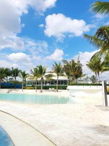 a swimming pool with palm trees and a building at Freila's Azure North in San Fernando