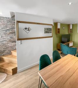 a room with a table and chairs and a wall at Maison 3 chambres 6 pers RER A, L Paris direct in Maisons-Laffitte