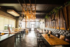 a restaurant with wooden tables and chairs and a chandelier at Bed Loft Cafe in Khon Kaen