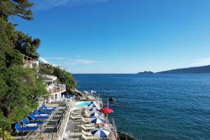 a row of blue and white umbrellas and the water at Grand Hotel Bristol Spa Resort, by R Collection Hotels in Rapallo