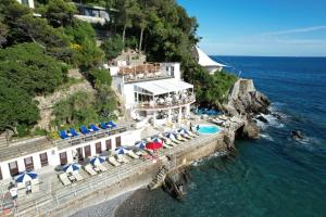 a resort with chairs and umbrellas and the ocean at Grand Hotel Bristol Spa Resort, by R Collection Hotels in Rapallo