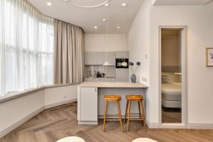 a kitchen with a counter and two stools at Hotel Kobalt - Den Haag in The Hague