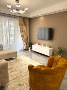 a living room with a couch and a flat screen tv at Alba gardens in Nairobi