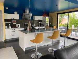 a kitchen with a counter and stools in a room at chez Nadege in Thivars