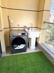 a bathroom with a sink and a washing machine at Alba gardens in Nairobi