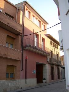 um edifício de tijolos vermelhos com varandas numa rua em Pensió Sant Antoni em Palau d'Anglesola