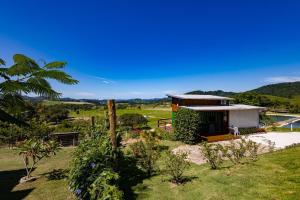 a house with a view of a field at Casa Container - Pousada Container da Montanha VERDE Banheira in Rio Fortuna