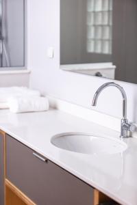 a bathroom with a white sink and a mirror at Chryssi 02, Comfort & Style, Centrally in Rethymno, close to the beach in Rethymno Town