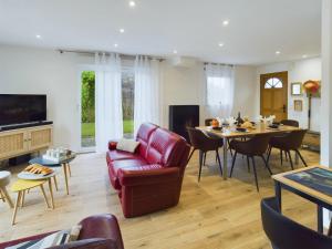 a living room with a red leather couch and a table at Maison pour 8 à Plomeur - Grand jardin in Plomeur