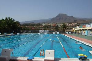 Una gran piscina con gente en el agua. en 2-bedroom on Los Cristianos beach, en Los Cristianos