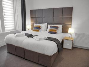 a bedroom with a large bed with a large headboard at Central Baxter Park Apt ! Free WiFi ! Sleeps 6 in Dundee