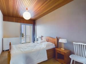 a bedroom with a bed and a table and a chair at Appartement pour 8 sur la Grande Plage de St Gilles in Le Sablais