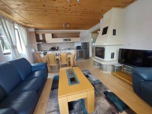 a living room with a blue couch and a table at Pamporovo Rhodopi Pearl Apartments - Private Apartments in Pamporovo