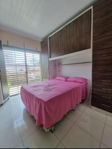 ein Schlafzimmer mit einem großen rosa Bett in einem Zimmer in der Unterkunft COP 30 Suíte Confortável com Varanda in Belém