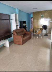 ein Wohnzimmer mit einer Couch und einem Tisch in der Unterkunft COP 30 Suíte Confortável com Varanda in Belém