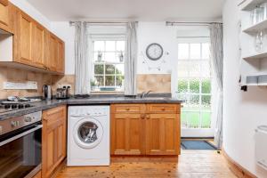 a kitchen with a washer and dryer at Smiddy Burn Cottage Kingsbarns in Kingsbarns