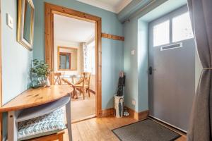 a room with a door and a table and a dining room at Smiddy Burn Cottage Kingsbarns in Kingsbarns