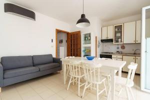 a living room with a couch and a table and chairs at Vista Mare Paradiso by Salento Prime in Torre Vado +6 photos