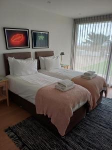 a bedroom with two beds with towels on them at 1 The Bay - Stunning contemporary flat on the Scottish coast in Coldingham