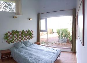 a bedroom with a bed and a large window at El Pinsapo in Segovia +26 photos