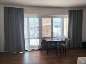 a dining room with a table and chairs in front of windows at Apartmán Vacovi in Olomouc +7 photos