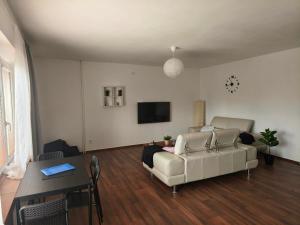 a living room with a white couch and a table at Apartmán Vacovi in Olomouc