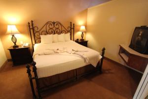 a bedroom with a bed with white sheets and a tv at Villas at Poco Diablo, a VRI resort in Sedona