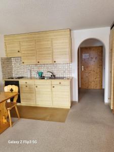 a kitchen with wooden cabinets and a sink at ELAfora Studio in Salouf