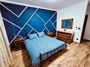 una camera da letto con un letto e una parete blu di Casa Antonelli a Ghemme