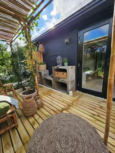 a wooden deck with a grill and a patio at By Tons Huisje inclusief twee fietsen in Zegveld