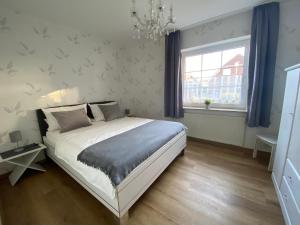 a bedroom with a large bed and a window at Landhaus Muhlenblick, Familie Ehnts in Carolinensiel