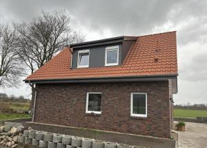 a brick house with a red roof at 3501 Weitblick über die Felder in Grönwohldshorst