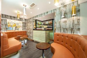 un ristorante con posti a sedere arancioni e un bar di Mercure London Paddington Hotel a Londra