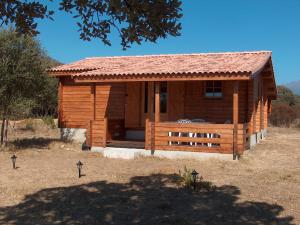 a log cabin with a porch in a field at chalet climatisé Porticcio Corse in Fontanaccio