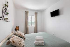 una camera da letto bianca con un letto e una televisione di Casa Otilia ad Arafo