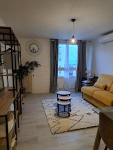 ニームにあるStudio Nimes - Clim - Wifi -Cuisine privatif - salle de bain commune- balconのソファとテーブルのあるリビングルーム
