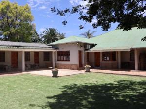 a building with a green roof and a yard at Boksburg Hotel in Boksburg