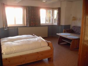 a bedroom with a bed and a couch and a table at Astrupgaard Farm Holiday in Skærbæk