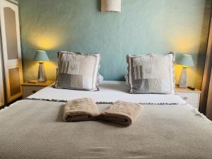 a bedroom with a bed with two towels on it at Le Patio Bleu in La Crau