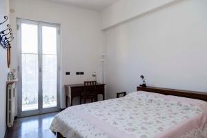 a bedroom with a bed and a desk and a window at Casa Europa - Arenzanohost in Arenzano