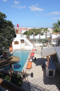 a view of a swimming pool with chairs and trees at La Maison des Vagues in Sidi Kaouki