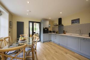 a kitchen and dining room with a table and chairs at Garden Cottage in Inverness