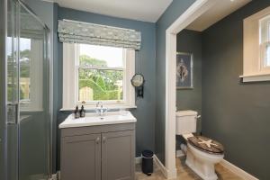 a bathroom with a toilet and a sink and a window at Garden Cottage in Inverness +22 photos
