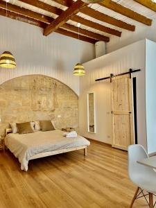 a bedroom with a large bed and a stone wall at Dimora Albicocca in Bari