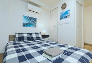 a bedroom with a blue and white checkered bed at #201WZNET梅屋敷駅2分横浜羽田空港都心便利商店街1k静かな町 in Tokyo